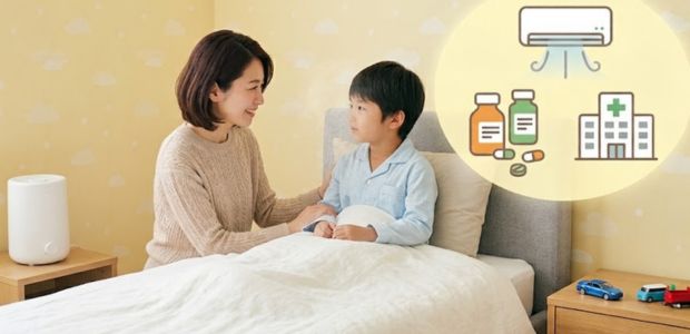 ベッドにいる男の子の体調を気遣う母親